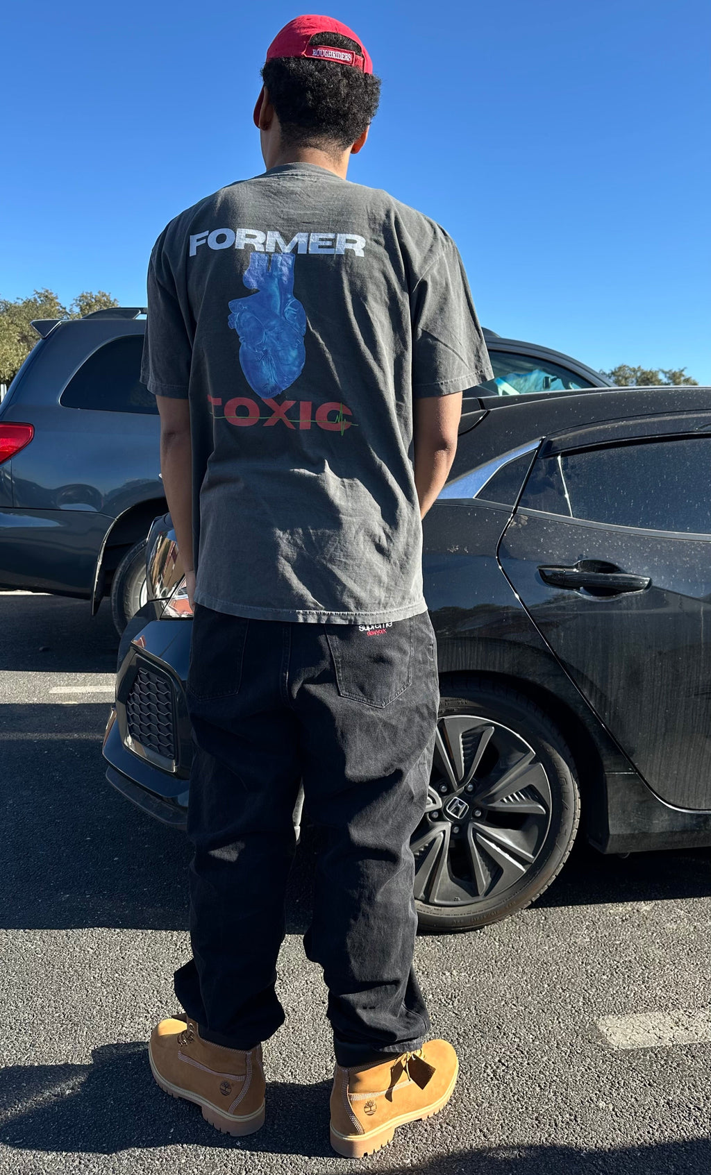 Back of Heat Scan Targeted Heart Tee showing blue anatomical heart graphic and Former Toxic logo on charcoal shirt outdoors.